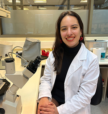 Ana Flores Leñero in a labcoat at a microscope