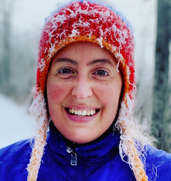 Dr Laura Castro de la Guardia wearing a red wooly hat in a snowy environment