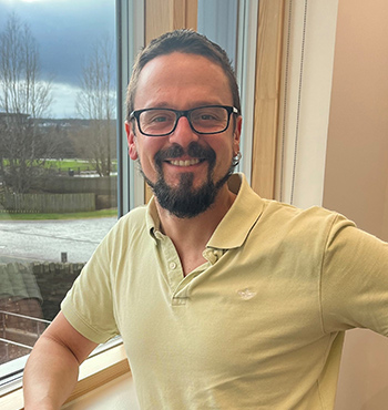 Business Development Manager Daniel Carcajona pictured on a dramatic coastal landscape.