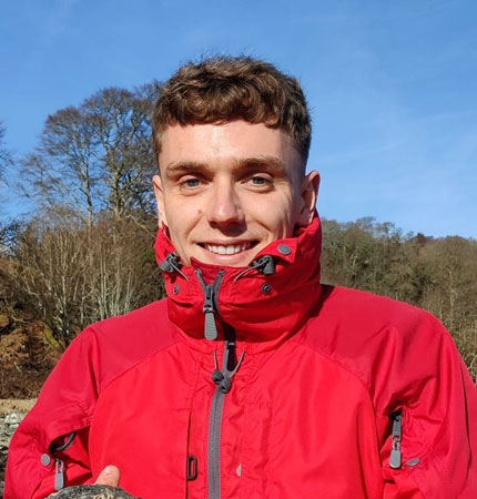 Head and shoulder photo of Aidan Jackson in a red coat outdoors
