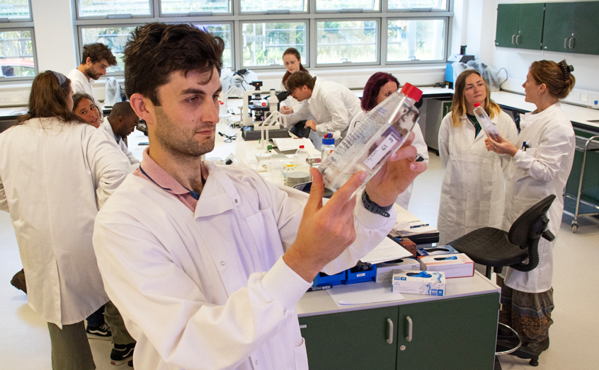 SAMS Enterprise seaweed nursery manager Rob Grisenthwaite examines a seaweed sample during the seaweed nursery course