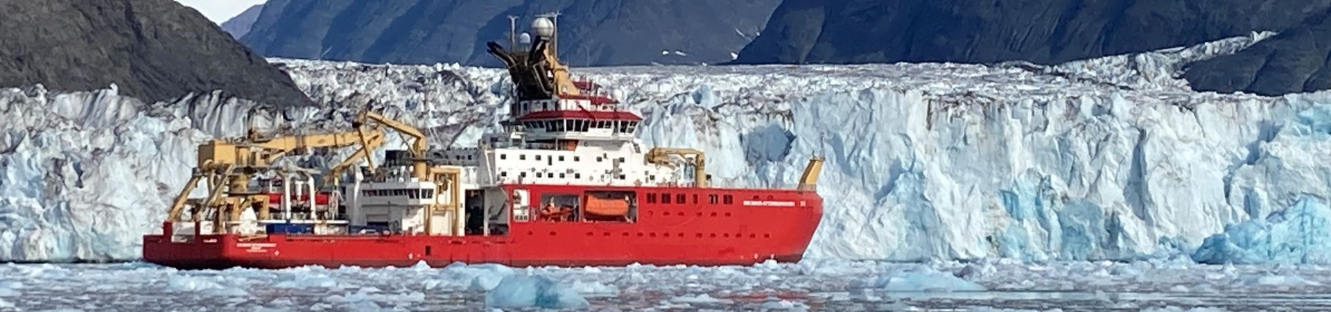 research vessel in front of glacier