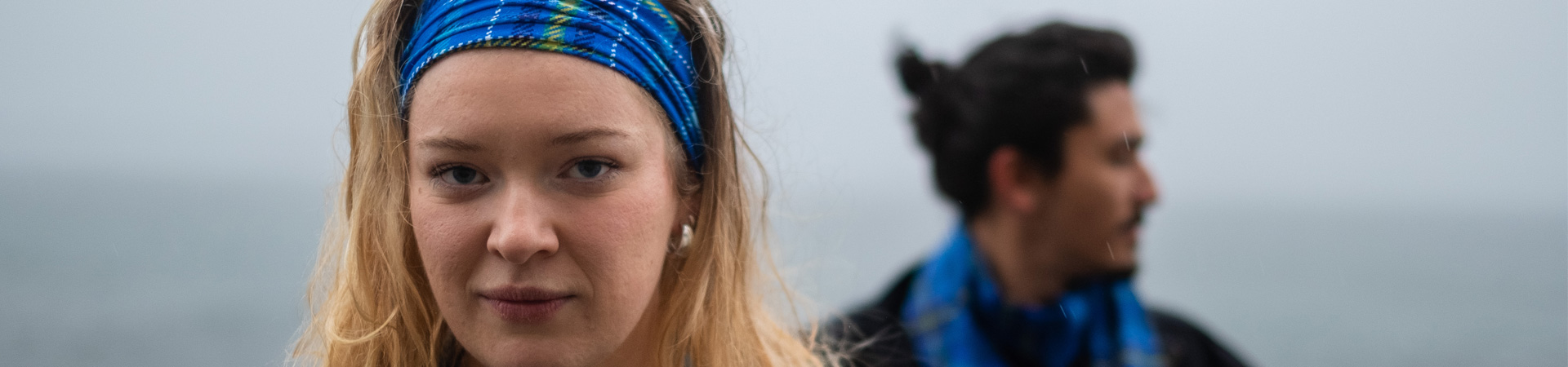 Young blond woman with Ocean Tartan head band and man with tartan scarf