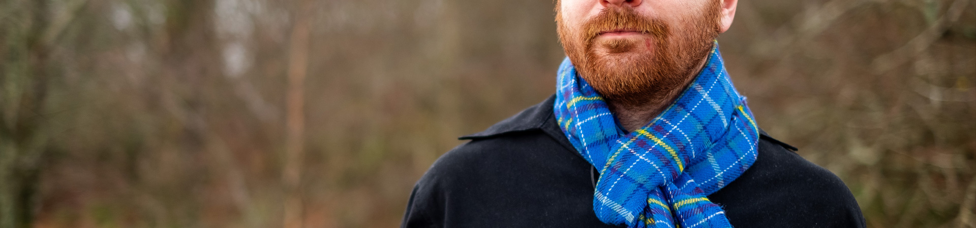 Bearded ginger man wearing an Ocean tartan scarf